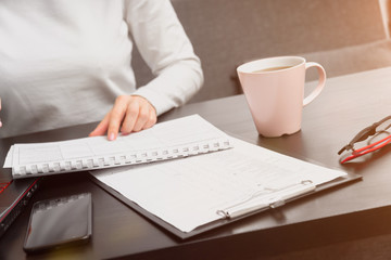 top view , a girl works on a laptop and writes data in a table. manager work concept.