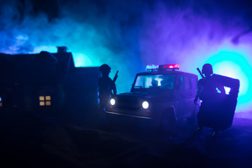 Obraz na płótnie Canvas Police cars at night. Police car chasing a car at night with fog background. 911 Emergency response police car speeding to scene of crime. Selective focus