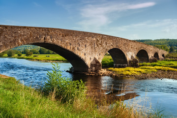 Fototapeta na wymiar Old Arch Bridge On Suir River In Ireland