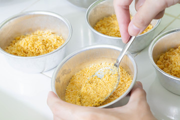 Closeup of spoon smashed crispy cracker in mould pan to make base of blueberry cheesecake. Process of cooking food. Homemade bakery. selective focus