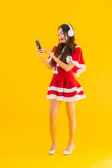 Portrait beautiful young asian christmas clothes and hat listen for music