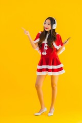 Portrait beautiful young asian christmas clothes and hat listen for music