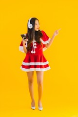 Portrait beautiful young asian christmas clothes and hat listen for music