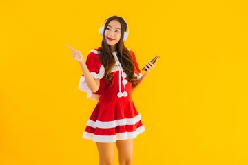 Portrait beautiful young asian christmas clothes and hat listen for music