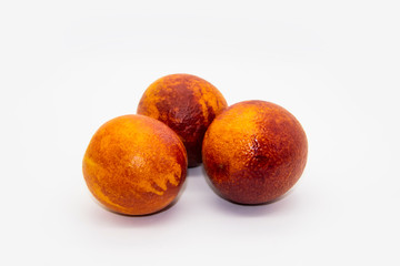 Three Sicilian ​​oranges on a white plate on a white background.  Sicilian oranges against background. Healthy and tasty red ​​orange.