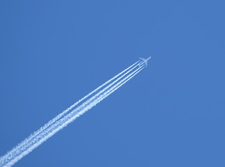 Jet plane in the blue sky with an inverse track