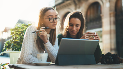 Girls drink coffee relax in cafe outdoor in europe city. Freelancer communicate on project, woman shopping online. Working business process © A_B_C