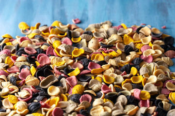 pasta made of durum wheat of different colors and shades, raw sprinkled on a table
