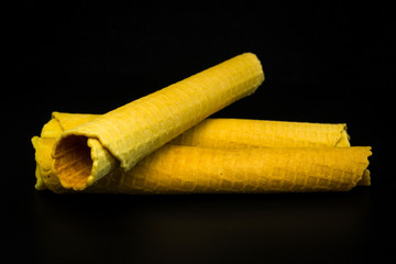 Wafer rolls with condensed milk on a white plate.