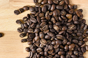 Top down view of spread coffee beans on wooden table. Concept of coffee culture.