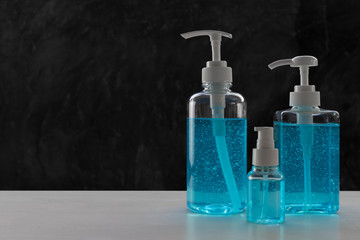Blue alcohols gel on white table and  calcium oxide background. Hand sanitizer gel for clean. Hand sanitizer in 3 different size dump bottle.