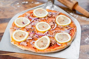 Pizza tonno fish on the wood table oven peel paddle