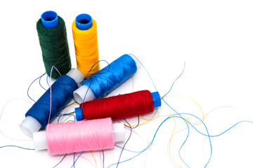 sewing supplies red blue yellow thread on bobbins, horizontal photo