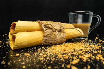Wafer rolls with condensed milk on a white plate.