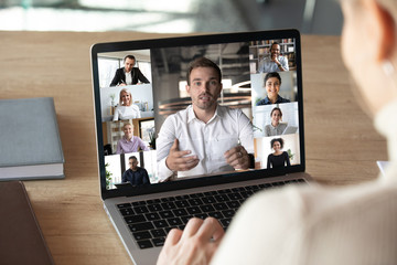 Close up of woman worker talk brainstorm on video call on computer with diverse colleagues, have...