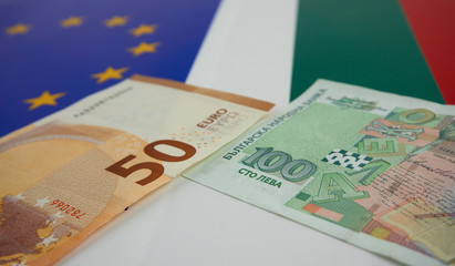 Bulgarian and European Union banknotes in front of EU and Bulgarian flag