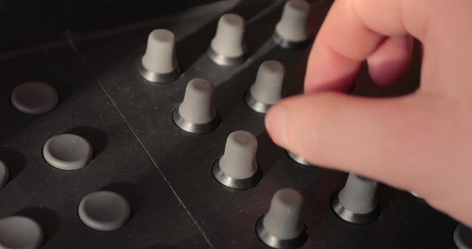 Turning knobs on a mixer board, studio mixing desk panel, digital audio equipment