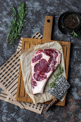 Raw beef steak on a dark wooden board