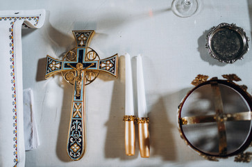 Church inventory. Cross, candles and crowns on the table in the church.

