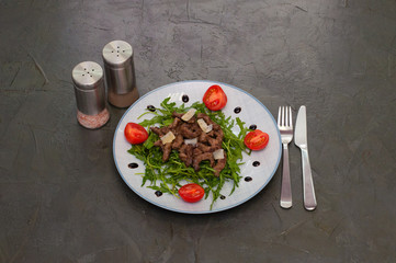 Tasty and juicy grilled meat arugula, cheese, tomato sauce and spices on a dark gray concrete background, top view