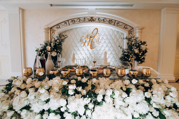 Decor of white roses at the wedding. Bridal table decorated with flowers.