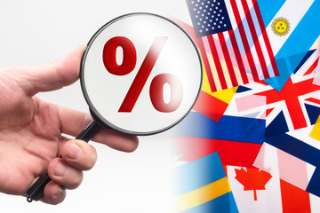 International rating. Concept - drawing ranking among states. Percent sign next to the flags. Hand with magnifying glass. Magnifier over a percent sign. Concept - interest rate in different countries