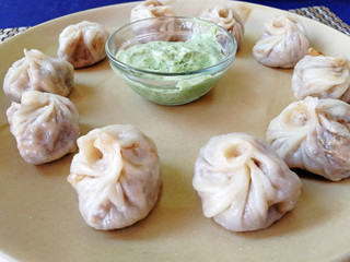 steamed Tibetan momos, the traditional dumplings with different fillings. served with sauce. Close up, side view