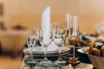 Beautiful table setting with crockery and flowers for a party, wedding reception or other festive event. Glassware and cutlery for catered event dinner.