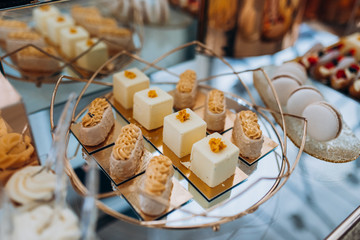 Eclairs with cream on buffet table. Delicious white mousse desserts and eclairs on the yummy sweet buffet and other sweet patisserie. 