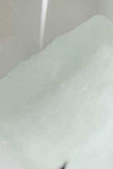 water flows from the tap into the bathtub