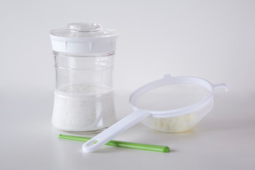 Kefir set with kefir grains, milk, plastic strainer and stirring stick