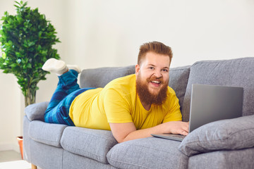 Funny fat man working online shopping shrpping watching a video at home in the room.