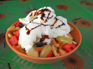 Fruit salad with Apple watermelon mango and grapes with white vanilla ice cream. Delicious and sweet dessert