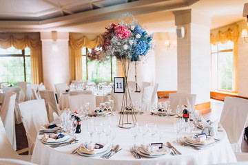 Beautiful flowers on table in wedding day. The white round banquet table in the restaurant is decorated with fresh flowers. 