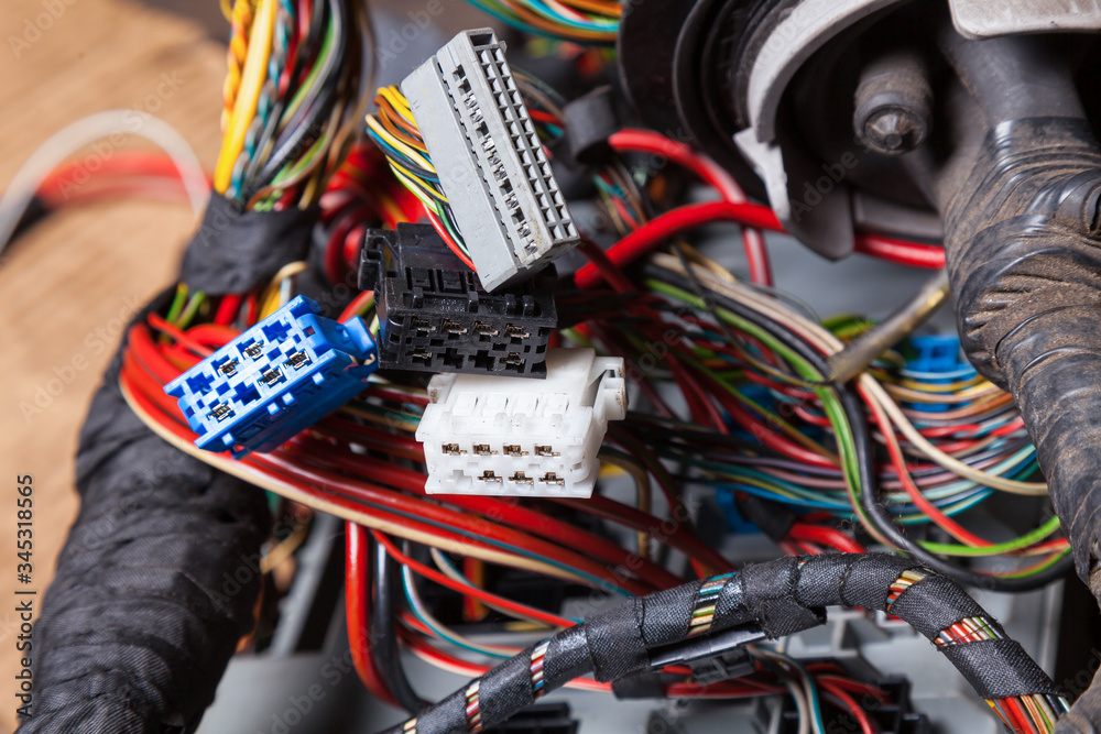 Canvas Prints Multi-colored electrical wires with connectors of white gray and blue colors in the nodes of the car rewound with insulation tape during network repair by an engineer or mechanic in a car service.