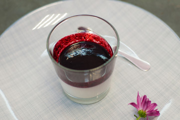 Italian festive dessert Panacotta with berry filling, in a glass, with spoon