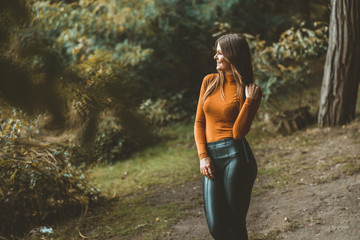 junge Frau posiert im Wald und lächelt