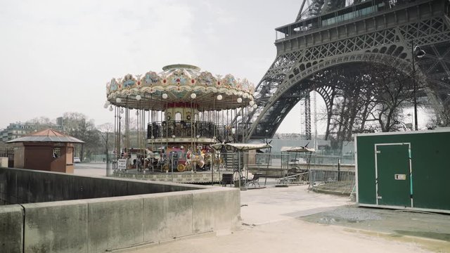 Paris, France / 04 13 2020: Closed carousel and deserted Eiffel tower during coronavirus / Covid-19 lockdown in Paris 4K