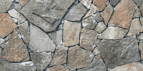 Rock texture, stone wall background. Mosaic pattern of old grey stones on floor. Wide panorama, panoramic banner. Grunge architecture facade, tiled frame.