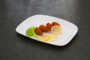 Crab claws fried in batter with lemon, lettuce and sauce