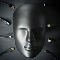 Inorganic human robot android face ready to connect with many digital device wires cables chargers. Digitalization, chipization, artificial intelligence, futuristic cyborg concept in total black color