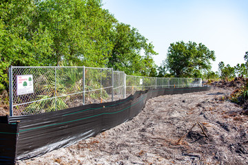 Trees are fenced off to protect them from heavy equipment as a new housing subdivision begins...