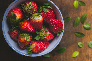 Strawberry bowls on a rustic wooden table
