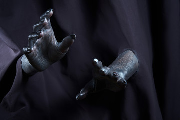 two beautiful man's hands in silver paint on a black background