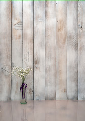 Flowers on vase on wooden background