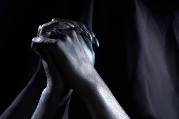 Naklejka premium two beautiful man's hands in silver paint on a black background