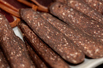 Sun-dried Basturma on a white plate. Traditional Armenian cuisine. Basturma Beef jerky. Top view