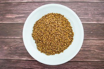 buckwheat in a plate on a wooden background.