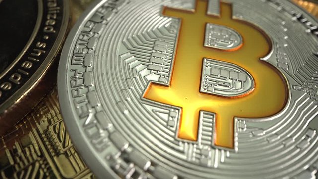 Super MACRO shot of Bitcoin BTC rotate on the table. Trading of gold coin before halving in May. Silver and Gold BTC and ETH. Laowa 24 mm Probe lens.