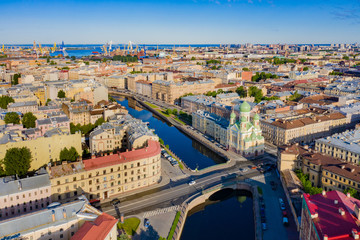 Fototapeta na wymiar Saint Petersburg from a height. Russia. Panorama of St. Petersburg on a Sunny summer day. St. Isidore's Church. Orthodox Church on the Griboyedov canal. Churches Of St. Petersburg. Mogilev bridge.